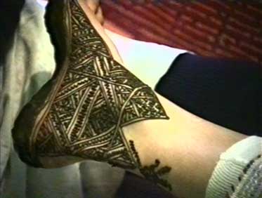 Das Dreieck ist ein Symbol der weiblichen Scham. Es war wie die Palme und der Fisch ein Symbolzeichen der karthagischen Fruchtbarkeitsgöttin Tanit. Mit Henna belegter Fuß